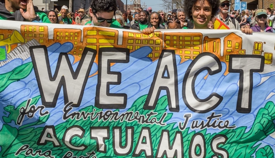 People march with a banner that says We Act for Environmental Justice