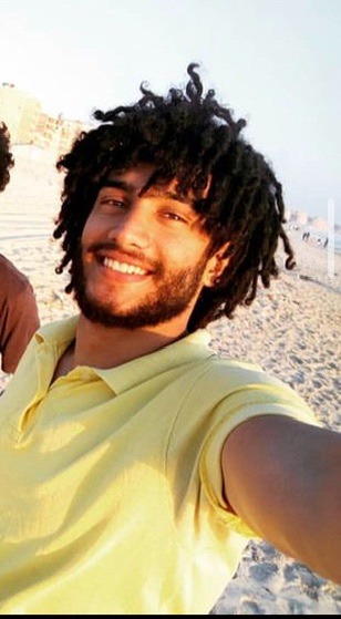 Badr Mohamed is wearing a yellow shirt and smiling into the camera in what appears to be a selfie.