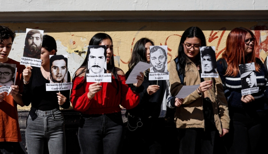 A group of young women hold pictures of victims of the Chilean dictator Augusto Pinochet.