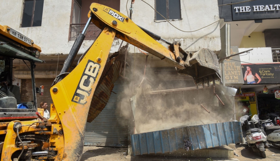 A bulldozer removes encroachments during an anti-encroachment drive by SDMC, at Shyam Nagar (West Delhi), on May 13, 2022 in New Delhi, India. The demolition drive began in Delhi on May 04 and it will continue till May 13. The civic bodies are taking stern action against the illegal land occupation in parts of Delhi. Photo by Sanchit Khanna/Hindustan Times via Getty Images