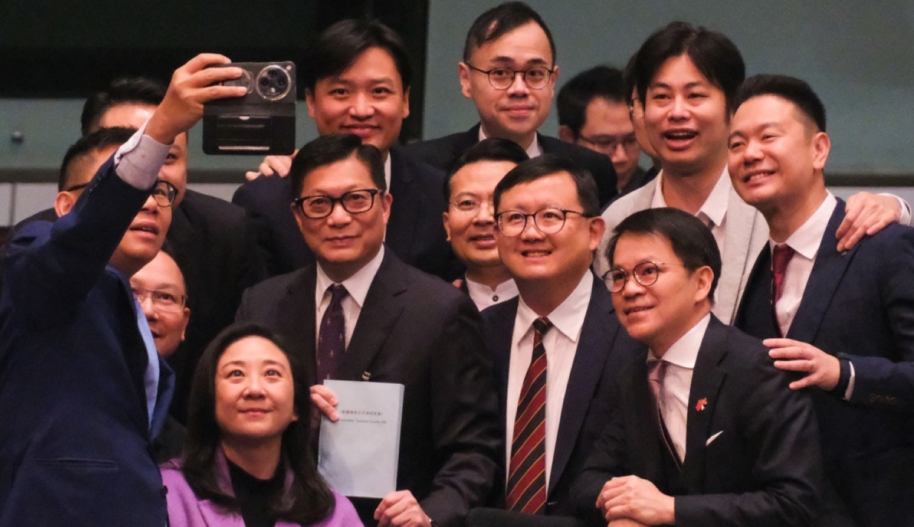 Hong Kong Secretary for Security Chris Tang Ping-keung (C) and lawmakers take a selfie after a meeting for Basic Law Article 23 legislation at the Legislative Council on March 19, 2024. Photo by Chen Yongnuo/China News Service/VCG via Getty Images.