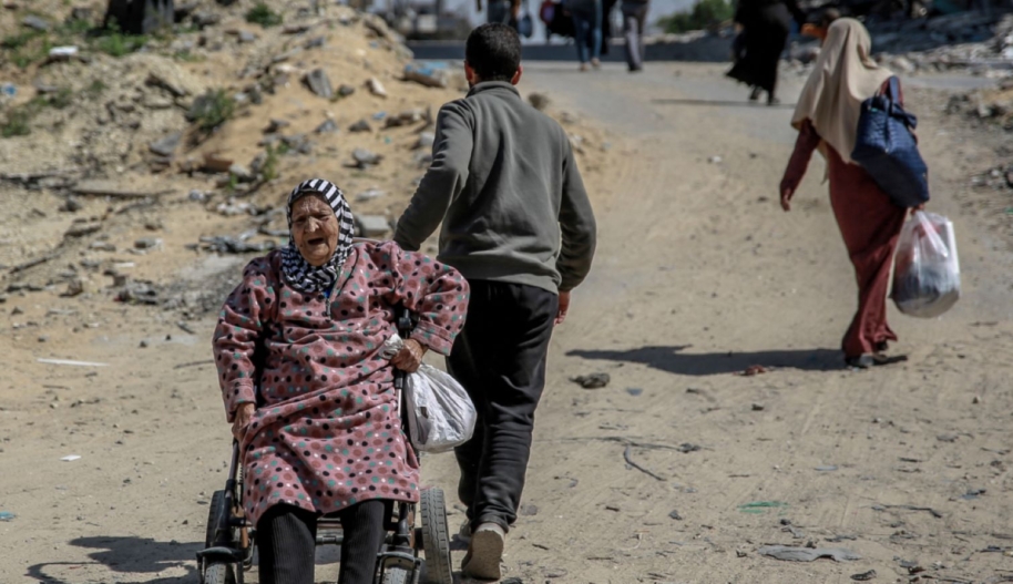 A man pulls an elderly Palestinian woman on a wheelchair as displaced families move in Gaza City, on March 25, 2024, amid the ongoing conflict between Israel and the Palestinian Hamas movement. Photo by AFP via Getty Images.