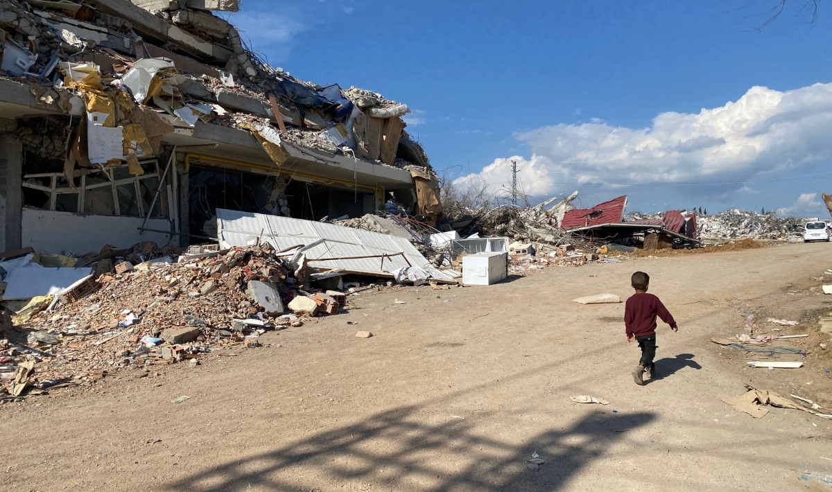 Boy walking by a building destroyed by the earthquakes in Gaziantep (Nurdagi), Türkiye March 2023